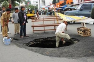 Tampak lubang berdiameter 1 meter di jalan Siliwangi sedang diperbaiki.
